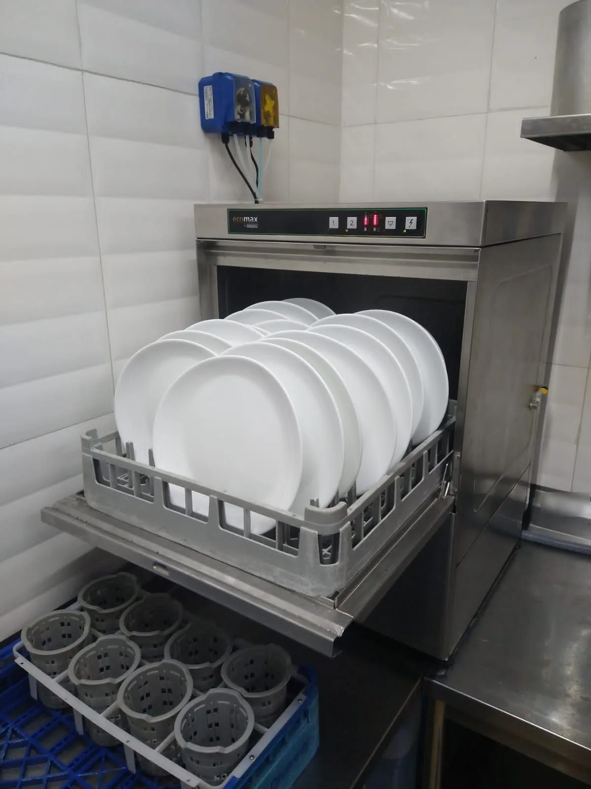 Lava-louças aberta com o rack cheio de pratos, na cozinha de um cliente da Unifort