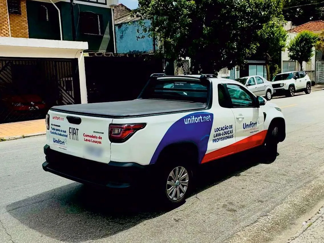 Picape da frota Unifort estacionada na rua, com unifort.net na lateral
